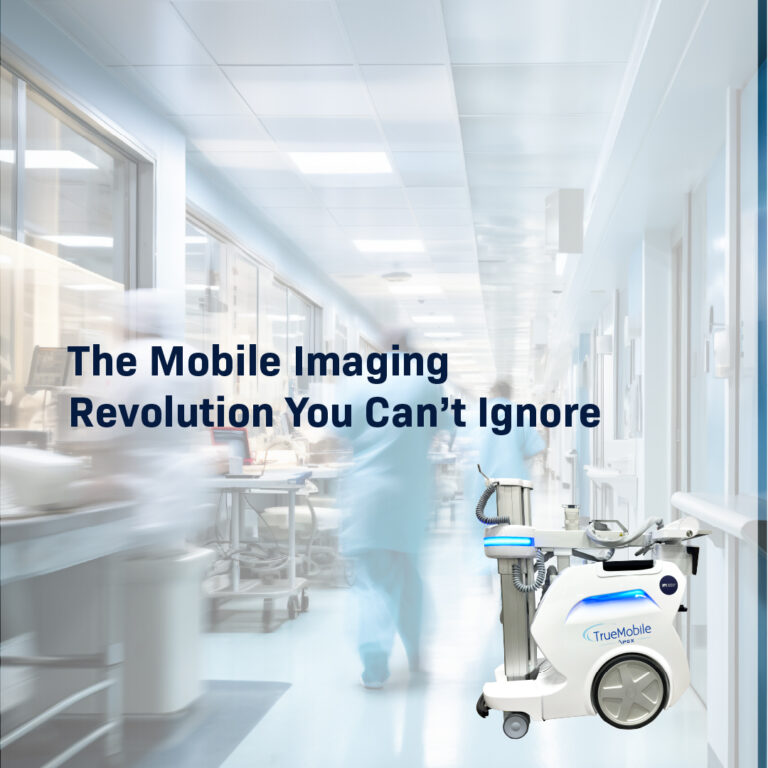 A sleek, white TrueMobile APEX mobile imaging unit positioned in a brightly lit, modern hospital hallway with blurred healthcare staff in the background.