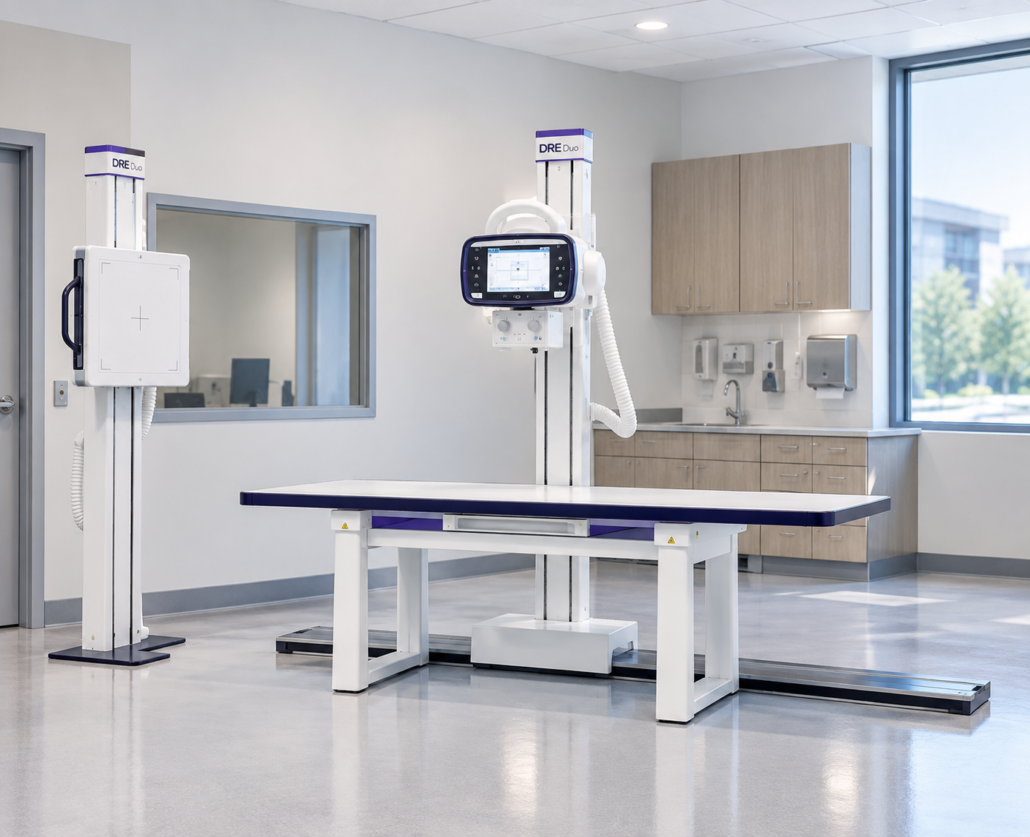 Modern medical room equipped with the JPI DRE Duo digital radiography system including X-ray table, floor-mounted tube stand, and a bucky stand